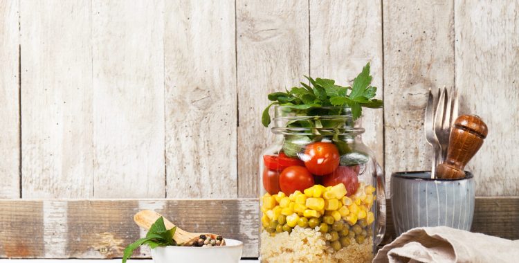 Homemade healthy layer salad in mason jar on a wooden background. Healthy life, food, detox concept